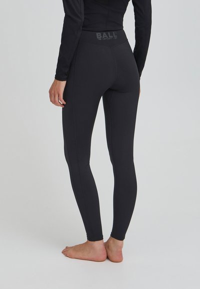 Crne atletske tajice s visokim pojasom. Izrađene od rastezljivog materijala s ravnim šavovima i logotipom otisnutim na stražnjem dijelu pojasa.