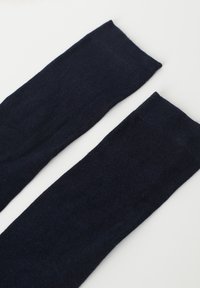 Calcetines marinos de longitud hasta la rodilla, fabricados en un material suave con una textura lisa y una banda superior reforzada para un ajuste seguro, sin patrones ni acentos visibles.