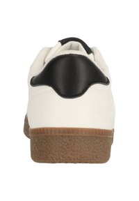 Vit sneaker med en svart läderhäll och en texturerad brun gummisula. Bakifrån visar den en slät ovandel och en rundad hälldesign.