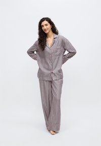 Conjunto de pijama a rayas en gris, rosa y blanco con una camisa de botones y pantalones holgados. Tela suave y bolsillo en la camisa.