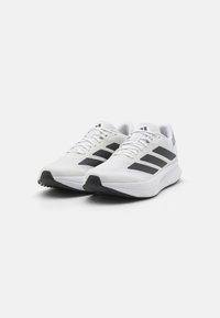 White athletic shoes with black stripes, made of textile and synthetic materials, featuring a lightweight design and rubber outsole for traction.