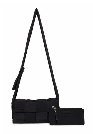 Sort polstret crossbody-taske med en lang rem, ledsaget af en lille matchende lynlåspose foran.