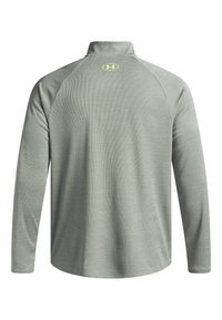 Hellgraues Longsleeve-Sportshirt mit hohem Kragen, strukturiertem Gewebe und kleinem reflektierenden Logo auf dem oberen Rücken.