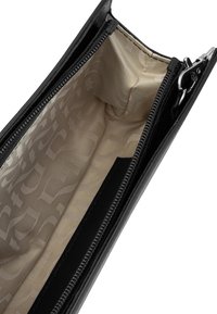 Crna kožna zip torbica s bež uzorkom unutarnjeg obloga. Ima glatku teksturu i dobro konstruiran detalj zatvarača.
