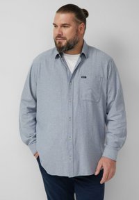 Jasnoniebieska koszula na guziki z długim rękawem, z kieszenią i metką. Wykonana z teksturowanej tkaniny, z klasycznym kołnierzem i zapinana z przodu na guziki.