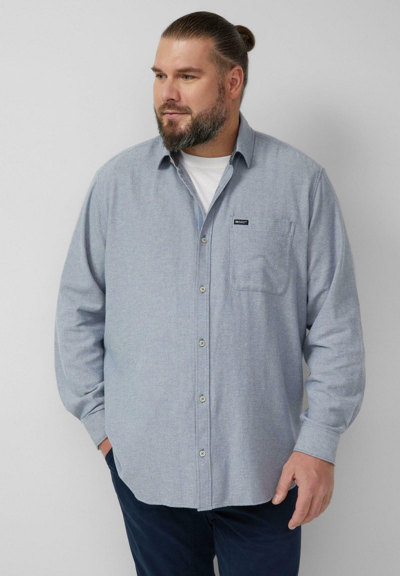 Jasnoniebieska koszula na guziki z długim rękawem, z kieszenią i metką. Wykonana z teksturowanej tkaniny, z klasycznym kołnierzem i zapinana z przodu na guziki.