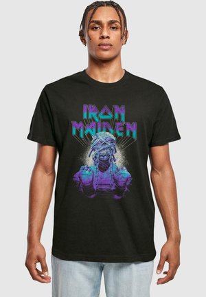 Sort bomulds T-shirt med et farverigt grafik i lilla og teal, der viser en karakter med kæder og tekst som siger "Iron Maiden."