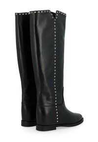 Bottes en cuir noir montant jusqu'au genou avec une semelle plate, ornées de clous en argent le long de la couture extérieure et d'une large ouverture en haut.