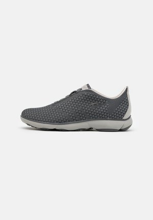 Sneaker slip-on nero e grigio con piccoli motivi geometrici bianchi e suola grigio chiaro, mostrato dal lato interno su sfondo bianco.