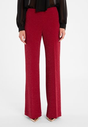 Rode glinsterende broek met wijde pijpen, een gladde textuur en een hoge tailleband, gecombineerd met gouden puntige hakken.