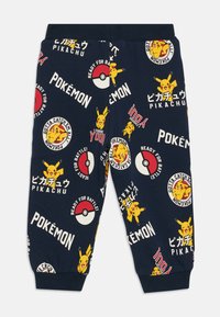 Námornícke joggery s celoplošným potlačou Pokémon, vrátane Pikachu, Pokéballov a textu v rôznych farbách a štýloch. Elastický pás a manžety.