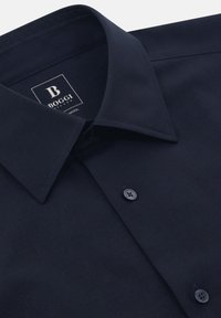 Camicia da uomo blu navy in lana, con colletto classico, pattina con due bottoni e una consistenza liscia con dettagli di cucitura discreti.