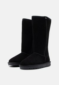 Μαύρες σουέτ μποτάκια μέχρι τον αστράγαλο με ψηλό σχέδιο, επίπεδη ελαστική σόλα και εμφανή λεπτομέρειες ραφής. Διαθέτουν μια μικρή μεταλλική λεπτομέρεια στο πλάι.