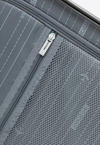Gray fabric zippered pouch with mesh panel, featuring stripe and logo details, and a silver zipper pull for easy access.
