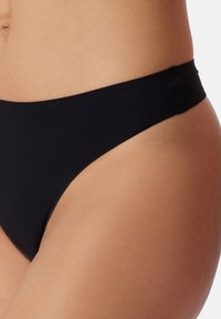 Czarny dół bikini o gładkiej fakturze, z wysokim stanem nogawek i prostym elastycznym pasem, zaprojektowany dla minimalnego zakrycia.