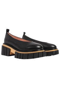 Scarpe slip-on in pelle nera con punta arrotondata, dotate di un'ampia suola in legno e di un spesso battistrada in gomma nera per una migliore aderenza.