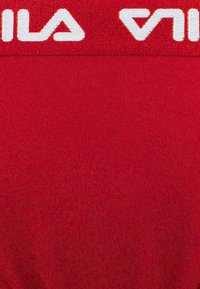 Tessuto sportivo rosso con texture a coste, caratterizzato da un grande marchio bianco "VILA" in alto.