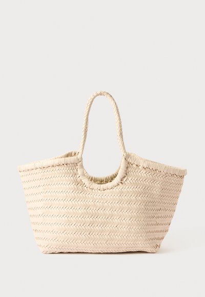 Sac fourre-tout en paille tissée beige, avec un corps large et deux poignées robustes, présentant un motif texturé et une ouverture en haut pour un accès facile.