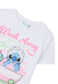 T-shirt bianco con un personaggio dei cartoni animati in una vasca da bagno con bolle di sapone rosa, accompagnato da testo colorato: "Lava Via i Tuoi Problemi."