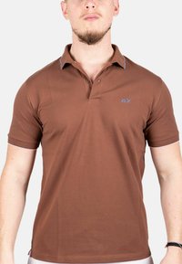 Bruine polo met korte mouwen gemaakt van katoen. Bevalt een knoopsluiting met twee knopen, contrasterende kraagafwerking en een klein blauw logo op de borst.