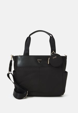 Zwarte Guess tote tas met korte handvatten, verstelbare schouderriem, voorvakken en een ronde pouch die aan één handvat is bevestigd.