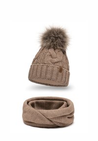 Bonnet beige tricoté avec un pompon en fourrure sur le dessus, assorti à une écharpe infinie beige avec un motif texturé.