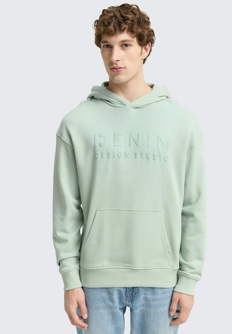 Mäta zelená mikina s textúrovaným povrchom, vybavená prednou kapsou, nastaviteľnou kapucňou a embosovaným nápisom „DENIM DESIGN STUDIO“ na hrudi.