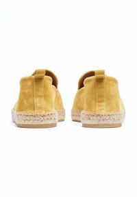 Espadrilles de ante amarillas con un acabado texturizado, que cuentan con una suela de yute y una pestaña trasera para facilitar el calzado.