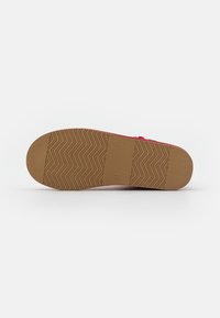 Semelle de chaussure avec une base en caoutchouc brun texturé présentant un motif en zigzag et des indentations circulaires, conçue pour adhérer et durer.