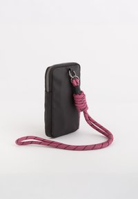 Svart tygpouch för telefonen med en texturerad yta, silverfärgad dragkedja och en rosa flätad rem med svarta accenter. Kompakt och rektangulär form.
