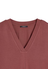 Top z krótkim rękawem w kolorze przybrudzonego różu z dekoltem w serek, wykonany z miękkiego, gładkiego materiału o delikatnej fakturze i przeszyciach przy dekolcie.