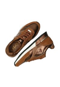 Bruna sneakers med en blandning av mocka och metalliska material, med en texturerad design och synlig logotyp, mot en vit bakgrund.