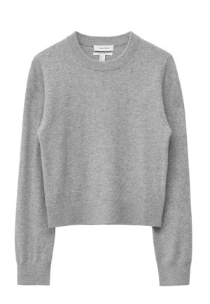 Grijze gebreide trui met een ronde halslijn, lange mouwen en een cropped ontwerp. Zachte textuur en geribbelde accenten bij de manchetten en zoom.