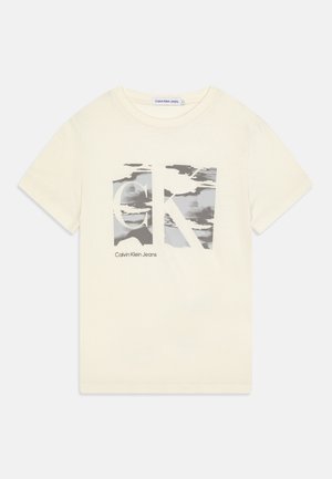 Kortærmet creme T-shirt med stort gråt og hvidt "CK" logo og "Calvin Klein Jeans" tekst foran.