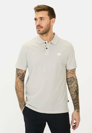 Lys grå polo t-shirt med et struktureret mønster, krave med to knapper og lille logo-detalje på brystet. Korte ærmer og en afslappet pasform.
