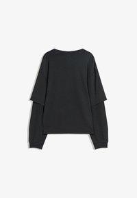 Fekete, túlságosan nagy póló, laza fazonnal. Széles kivágással, rövid ujjakkal rendelkezik, és texturált díszítéssel a hosszú ujjak alsó részén.