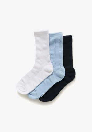 Tres pares de calcetines de caña con estampado en blanco, azul claro y negro, colocados planos y superpuestos sobre un fondo blanco.