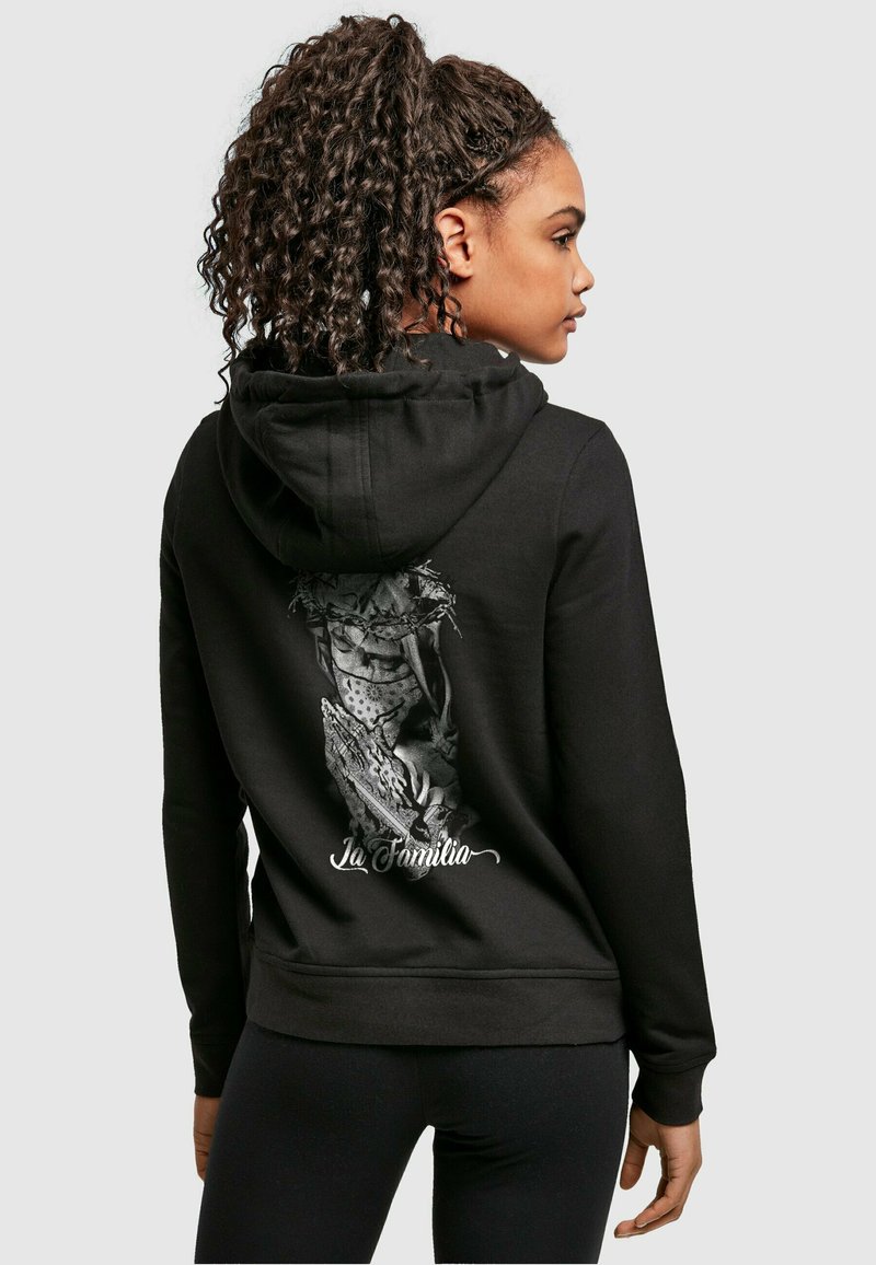 Black hoodie featuring a graphic design on the back with a figure, text "La Familia," and a front kangaroo pocket. Smooth fabric texture.
