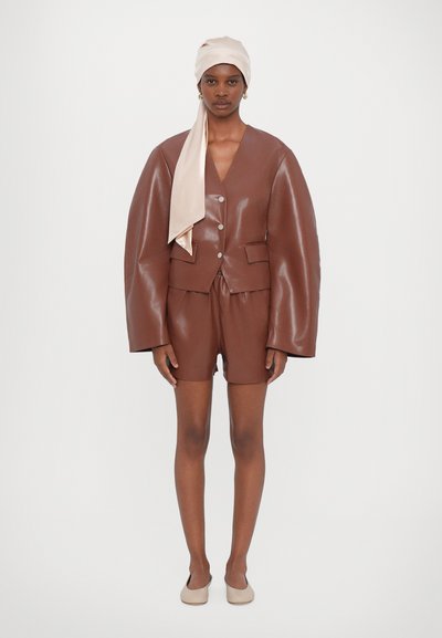 Brun faux læder oversized jakke med brede ærmer, matchende brune shorts og et lys beige satin hovedslør. Glat tekstur hele vejen igennem.