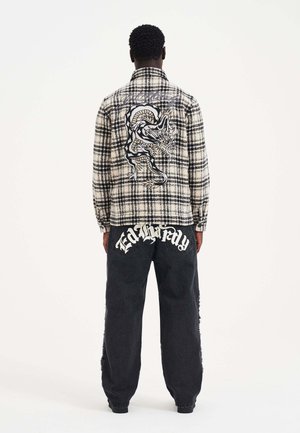Black and white plaid shirt with a dragon graphic on the back, paired with loose-fitting black jeans featuring "Ed Hardy" logo on the pockets.