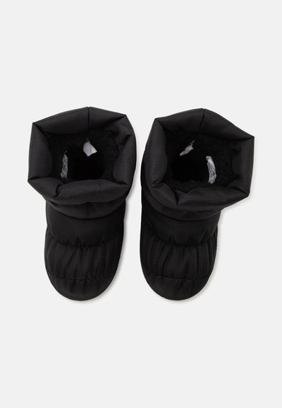 Paire de bottes d’hiver noires matelassées avec une doublure douce, vues de dessus sur un fond blanc uni.