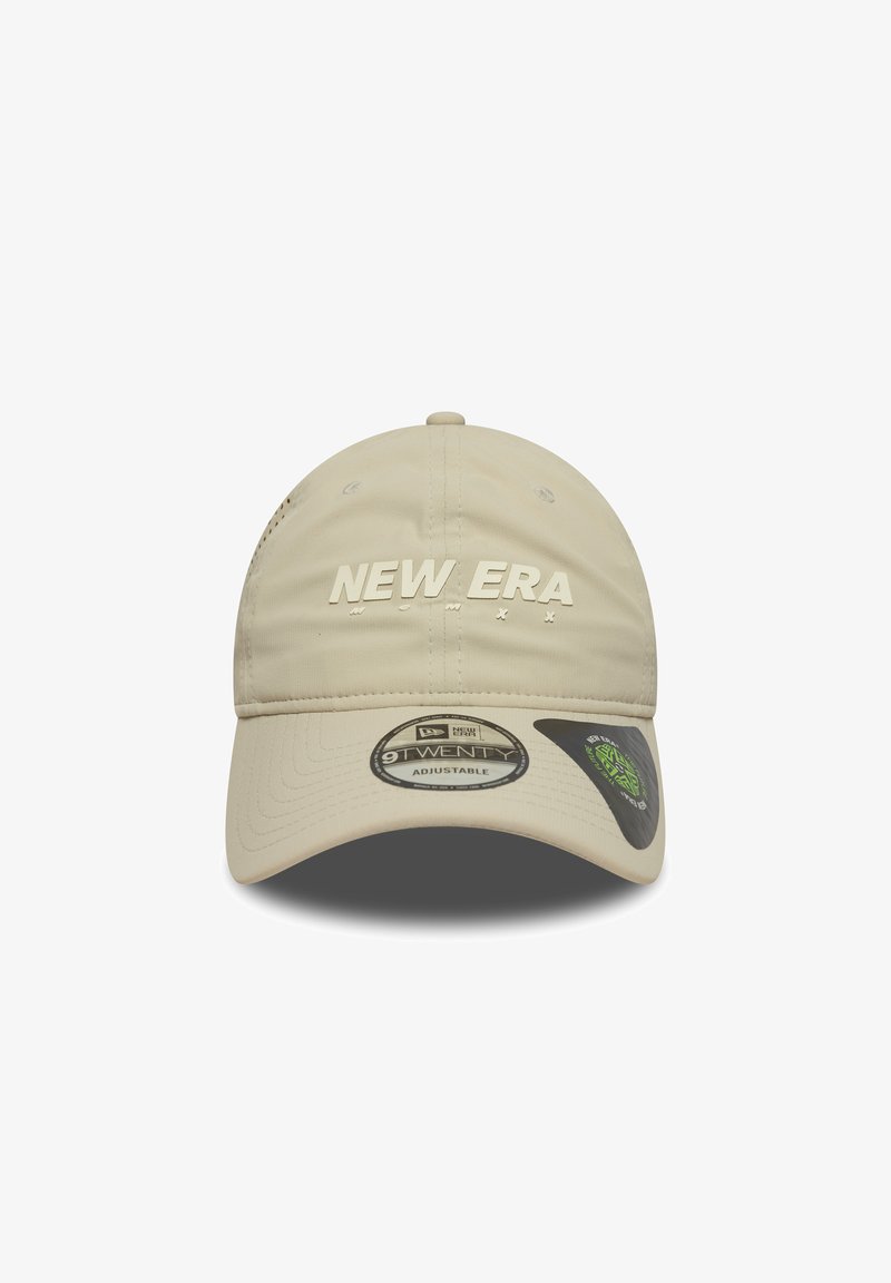 Beige adjustable cap with "NEW ERA" logo in raised lettering. Features a smooth fabric texture and rounded visor design.