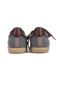 Szare trampki w wzór jodełki z brązowymi skórzanymi akcentami, beżową gumową podeszwą i płaskimi brązowymi sznurowadłami. Widok z tyłu pokazuje szczegóły skórzanej zakładki na pięcie.