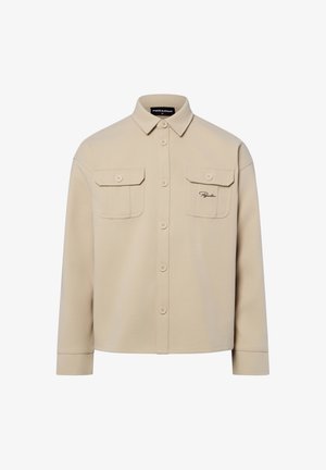 Camicia beige con bottoni in morbido tessuto strutturato, con due tasche frontali e un piccolo logo ricamato sul lato sinistro.