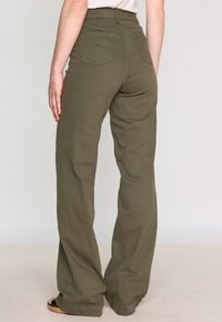 Pantalon large vert olive à taille haute, en tissu coton, avec deux poches arrière et une texture lisse.