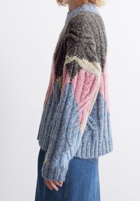 Flerfärgad stickad tröja med geometrisk design i nyanser av grått, rosa, blått och kräm; texturerade stickmönster och ribbade mudd. Back