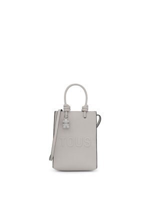 Sac à main en cuir blanc avec un logo "TOUS" en relief, anses, bandoulière réglable et détail en forme d'ours.