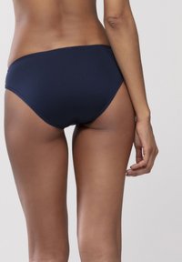 Niebieskie bikini w kolorze granatowym, wykonane z gładkiego materiału, o niskim stanie, z czystym cięciem i subtelnymi detalami ściegów.