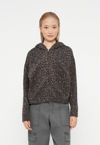 Hoodie cinzento com padrão de leopardos, feito de um tecido suave, apresentando um fecho de correr na frente, capuz com cordão e mangas longas. Estilizado com calças cargo cinzentas.