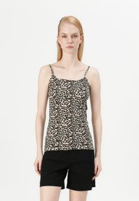 Løveprikket klesskjorte med tynne justerbare stropper, lett stoff, tettsittende design og rund hals, sammen med svarte shorts.